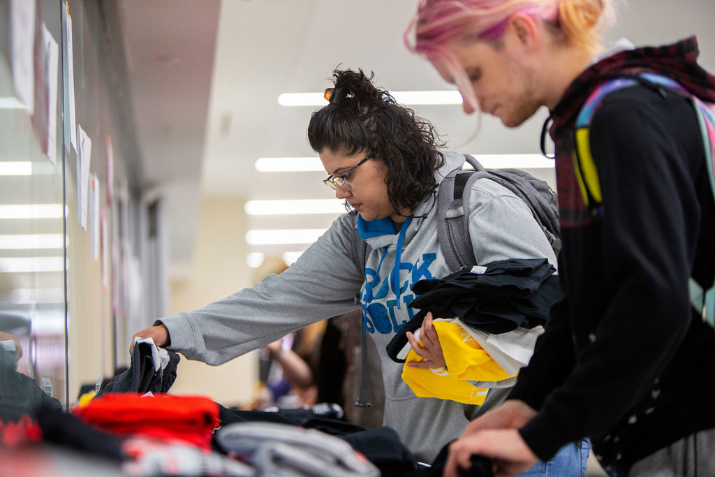 students looking at clothing during a campus event
