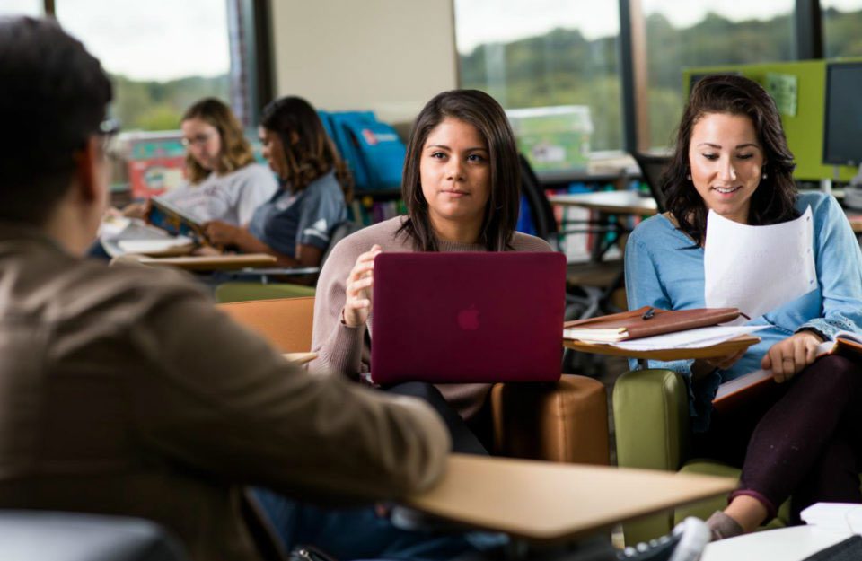 students in classroom with laptop